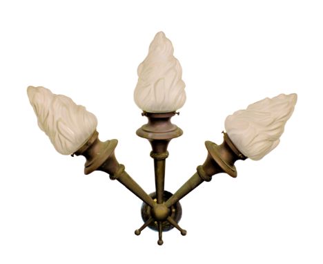 An early 20th century three branch wall light with flambeau frosted glass shades, the cast metal bracket with three tapering 