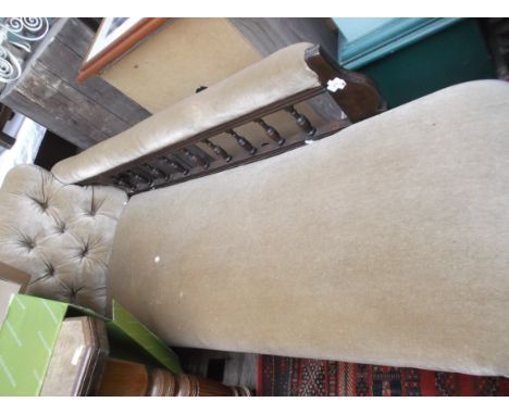 Oak framed chaise longue, the sweeping button back, seats and arms upholstered in light brown dralon (in need of repair)