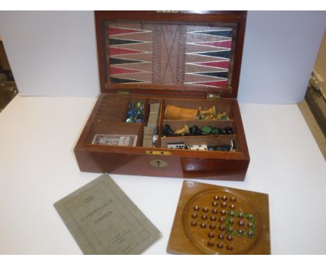 A mahogany cased games compendium containing various games pieces including Chess, Draughts, Dominoes, playing cards, Cribbag