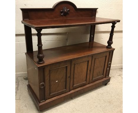 A Victorian mahogany buffet, the raised back over a single shelf on turned and fluted supports on a three door base 134 cm wi