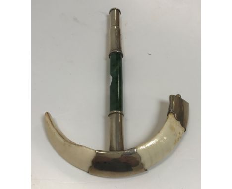 A Burmese white metal mounted boar tusk and jade parasol handle, mounts stamped "S Mc L", 17 cm long and a Tibetan brass and 
