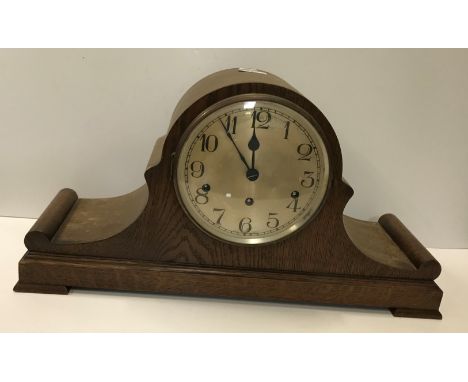 A large oak cased dome top mantel clock, the silvered dial with Arabic numerals together with an Ansonia Clock Co eight day m