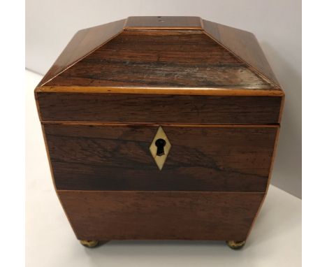 A small Regency rosewood sarcophagus shaped single section tea caddy with satinwood stringing opening to reveal lidded compar