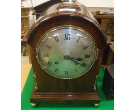 A Victorian mahogany cased mantel clock, the domed top with brass handle, the eight day movement with silvered dial and Roman