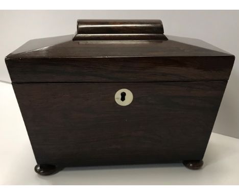An early 19th Century rosewood sarcophagus shaped two section tea caddy on squat bun feet 22.5cm wide x 16cm high together wi