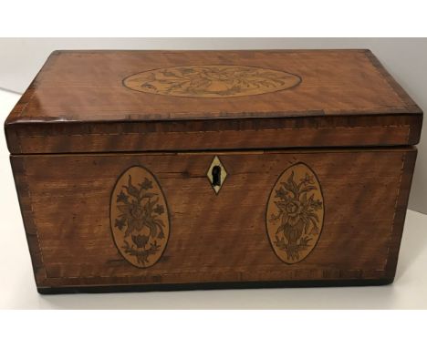 A late George III satinwood and marquetry inlaid tea caddy with floral medallion decoration opening to reveal a three section