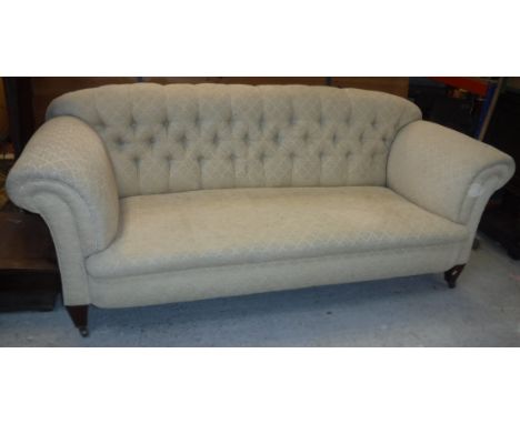 A circa 1900 upholstered scroll arm button back sofa on square tapered legs to brass caps and castors approx. 202 cm wide x 8