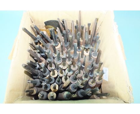 Approximately 90 metal number and letter punch tools, possibly for bookbinding.