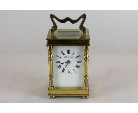 A French brass carriage clock with Roman numerals, with turned uprights on button feet, retailed by Harrods, 14cm