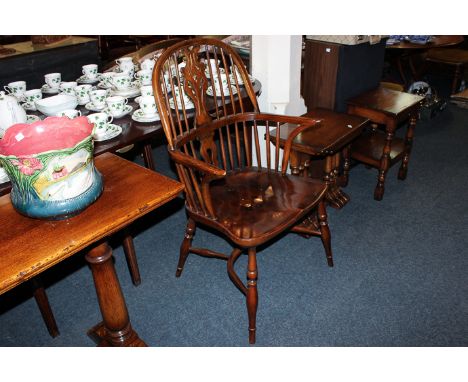 An 18th century style Windsor stick back elbow chair with fretted back splat and elm seat and crinoline stretcher rail