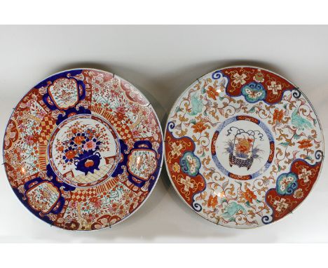 A late 19th century large Imari circular dish decorated in traditional colours with flowers, butterflies and central jardinie