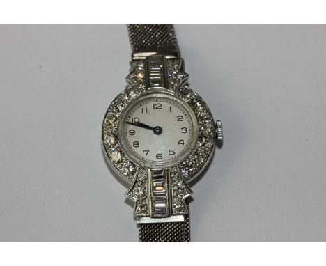 A fine diamond set cocktail watch with circular case the bezel set with ten brilliant cut diamonds the shoulders each set wit