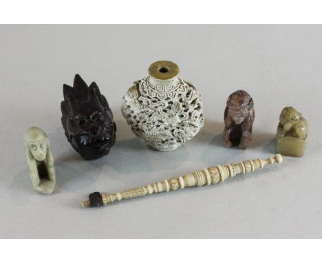 A Chinese ceramic scent bottle, 6.5cm, a carved wood dragon's head box, two carved stone monkeys, a Chinese seal and a bodkin