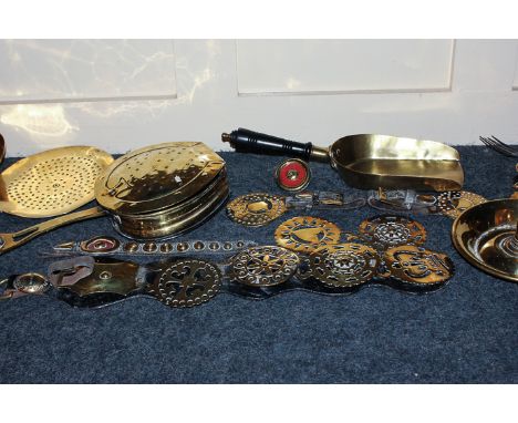 A collection of brass items to include a chamber stick, trivet, toasting fork, chestnut warmer, coal shovel, horse brasses, e