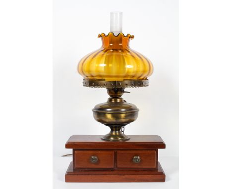 A wooden mounted electrified oil lamp with amber shade and chimney