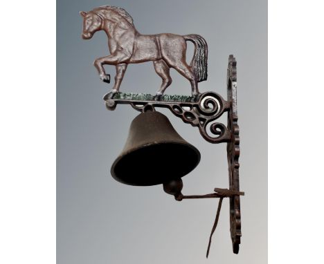 A cast iron horse wall bracket with bell.