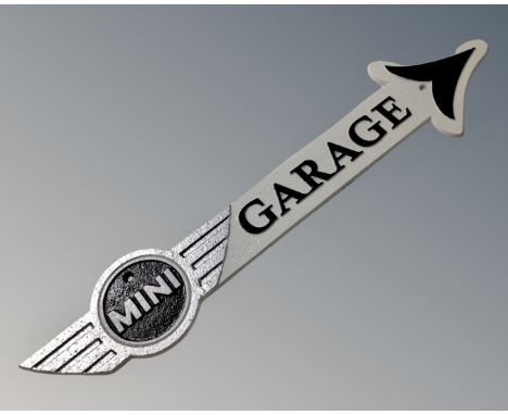 A cast iron Mini garage arrow plaque.