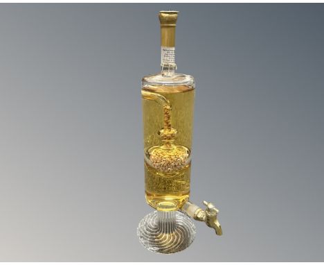 A novelty bottle of Highland malt scotch whisky in the shape of a tall carafe with decanting tap and an inner feature filled 