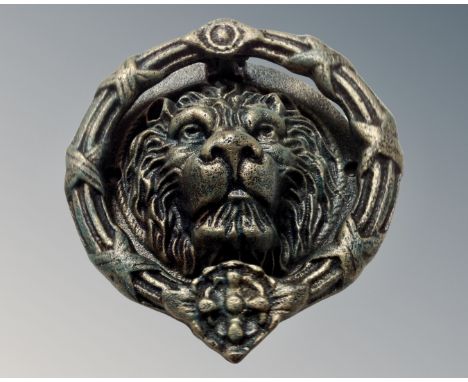 A cast iron lion head door knocker, width 21 cm.