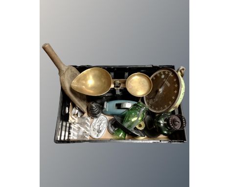 A box containing vintage kitchenalia, a green glass oil lamp, wooden scoop, Rolls-Royce engine cap.