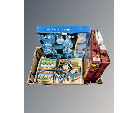 A box containing Lord of the Rings chess set together with a  glass three-in-one chess set and a box containing Warhammer fig