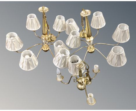A pair of contemporary brass six way light fittings, with shades, together with a further brass three way light fitting.