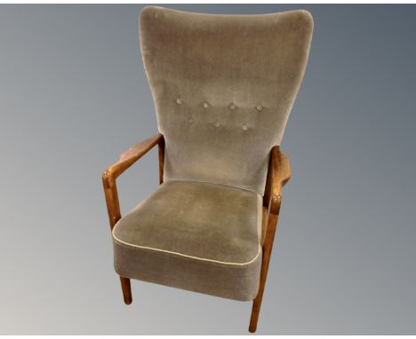 A beech fireside armchair upholstered in blue button dralon.