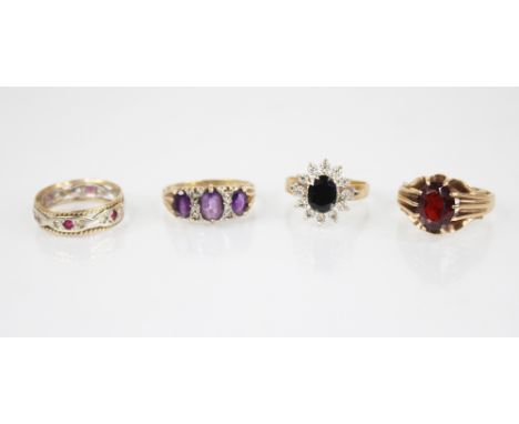 An amethyst and diamond ring, comprising three oval mixed cut amethysts, central amethyst measuring 7mm x 5mm, interspersed b