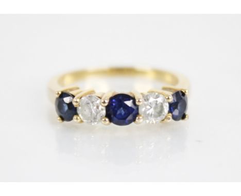 A sapphire and diamond five stone ring, the central round mixed cut blue sapphire measuring 4.6mm diameter, with two round br