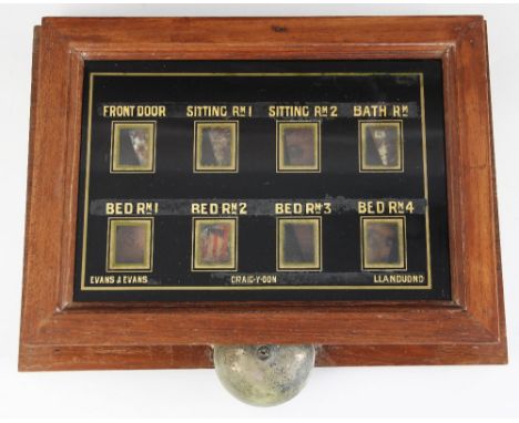 An early 20th century mahogany cased servants bell board, the glazed panel with eight windows above a protruding saucer bell,