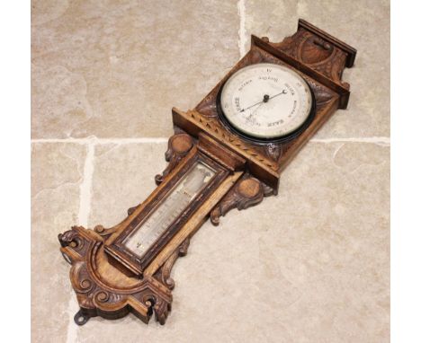 A Victorian carved oak wall barometer by Sewill, Liverpool, the case carved with 'C' scroll and foliate detail enclosing the 