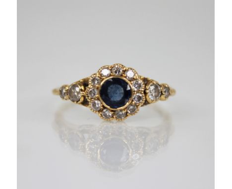 An early 20th century sapphire and diamond floral cluster ring, the central round mixed cut sapphire measuring 5mm diameter, 