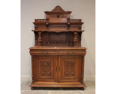 A late 19th/early 20th century French carved oak and rouge marble buffet sideboard, the architectural raised back with carved