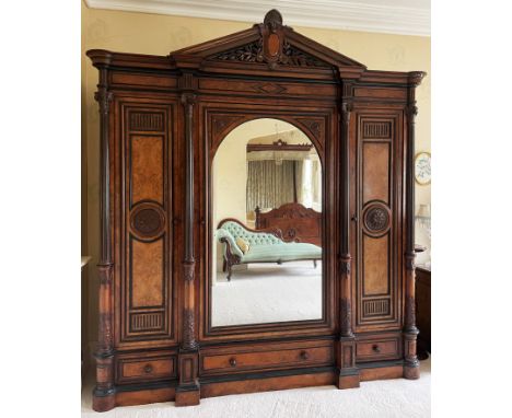 A large and impressive late 19th century French figured walnut compactum wardrobe, of architectural form, with central mirror