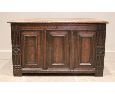 An early 18th century oak coffer, the rectangular moulded top over three front panels, enclosed by fluted pilasters and raise