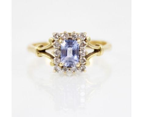 An iolite and diamond 18ct gold ring, the central rectangular step cut iolite measuring 6mm x 4mm, with a surround of round m