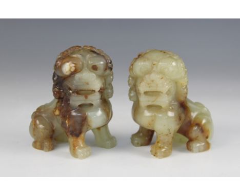 A pair of Chinese carved jade coloured dogs of fo, each modelled seated on hind legs, 9.5cm high 