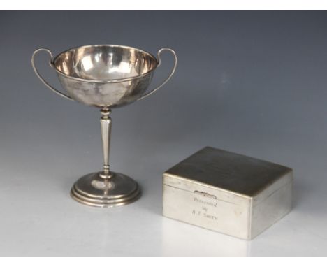 A silver coloured twin-handled trophy cup, the circular bowl with loop handles on tapered stem and stepped circular base, ins