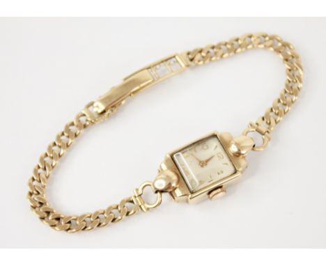 A ladies vintage 9ct gold wristwatch, the cream rectangular dial with Arabic numerals and baton markers, set to a plain polis