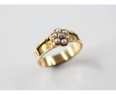 A 19th century pearl set memorial ring, designed as a floral cluster set with half pearls, set upon a gold coloured band with