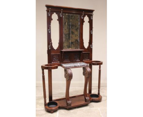 A late Victorian walnut mirror back hall stand, the rectangular mirrored back above a marble shelf raised upon a pair of carv