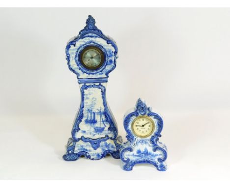 DELFT STYLE CLOCKS. An early 20th century Delft style, earthenware clock decorated with boating scenes. Height 41cm. Also, a 