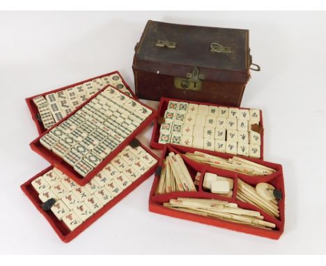 MAHJONG SET. An early 20th century, bone & bamboo mahjong set with four trays of tiles & an upper tray of sticks, dice, blank