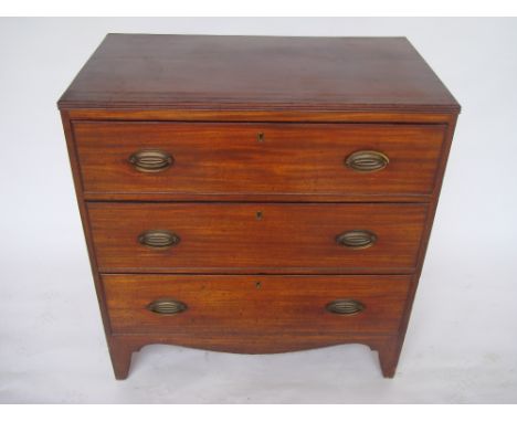 A George III mahogany chest of drawers, the top with reeded edge, above three graduated cockbeaded drawers in oval brass hand