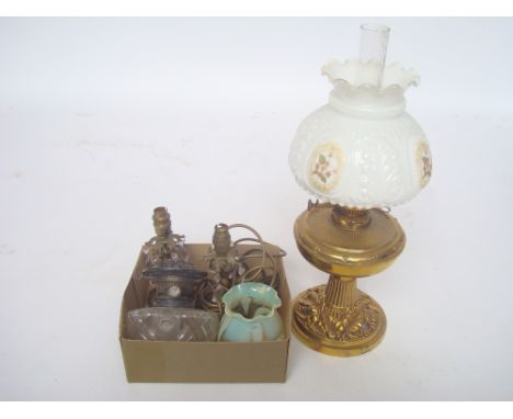 A late Victorian oil lamp with repousse decorated brass base and moulded white glass shade together with a pair of brass tabl