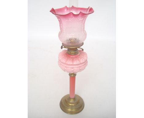 A Victorian brass oil lamp with moulded pink glass reservoir and stem complete with acid etched shade.   