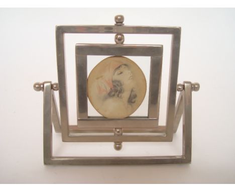A 1930's chromed swivel photograph frame, mounted with a pencil and watercolour portrait of young woman, written verso by Cha