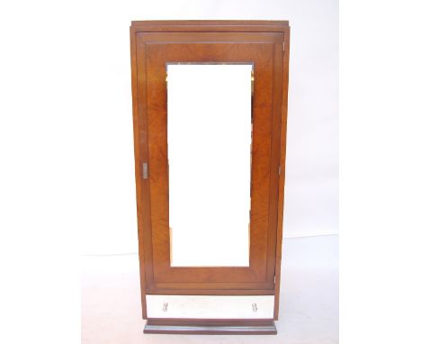 A French Art Deco mahogany and amboyna wardrobe, with single bevelled mirror door enclosing a single shelf and hanging rail a