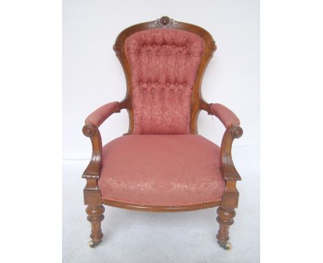 A Victorian walnut framed armchair with carved frame, buttonback upholstered back and padded open arms on srolled supports, o