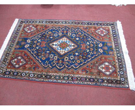 Middle Eastern Wool Tasseled Rug, tightly knotted, with central symmetrical lozenge within blue hexagonal panel on red ground